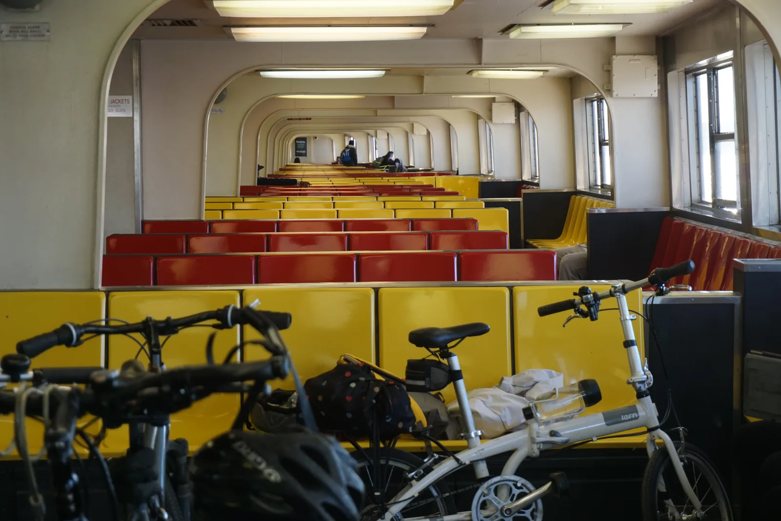 The interior of the Staten Island Ferry with its yellow and red seats and commuter bicycles